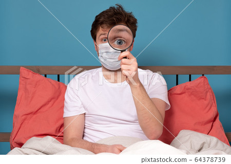 man in medical mask looking through magnifying man in medical mask looking through magnifying 64378739