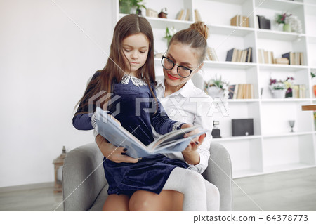 Tutor with litthe girl studying at home Tutor with litthe girl studying at home 64378773