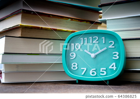 Clock and stacked books Clock and stacked books 64386825