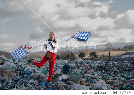 Modern woman on landfill, consumerism versus pollution concept. Modern woman on landfill, consumerism versus pollution concept. 64387739