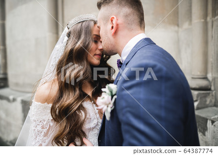 Gorgeous happy couple standing close to each other and looking in eyes Gorgeous happy couple standing close to each other and looking in eyes 64387774