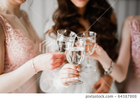 Photo bride with her friends drinking champagne from glasses Photo bride with her friends drinking champagne from glasses 64387808