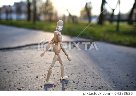 Wooden mannequin with face mask in town, corona virus and lockdown concept. Wooden mannequin with face mask in town, corona virus and lockdown concept. 64388626