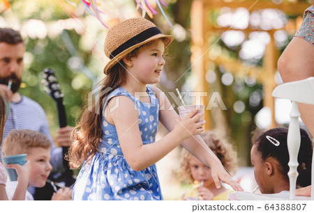Small children on ground outdoors in garden in summer, playing. 64388807