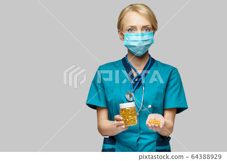 medical doctor nurse woman wearing protective mask and rubber or latex gloves - holding can of pills medical doctor nurse woman wearing protective mask and rubber or latex gloves - holding can of pills 64388929