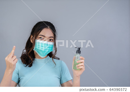woman in medical mask(surgical mask) holding woman in medical mask(surgical mask) holding 64390372