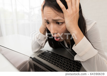 婦女拿著她的看膝上型計算機的頭。 婦女拿著她的看膝上型計算機的頭。 64390639