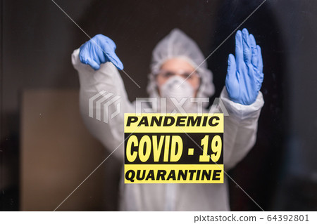 Woman in protective suit and in protective medical mask showing stop gesture. Epidemiologist show stop palm. Stop coronavirus or covid-19 and the pandemic. Stay home. Quarantine concept. 64392801
