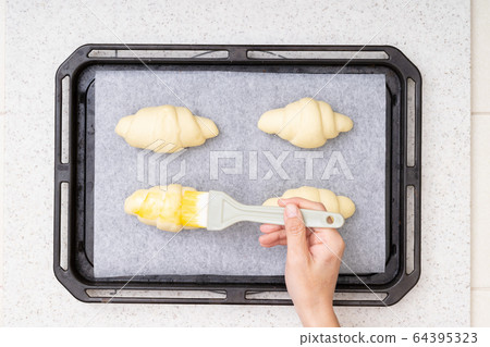 在家烘焙，黃油卷工藝5。將蛋黃塗到麵包麵團上的場景 64395323