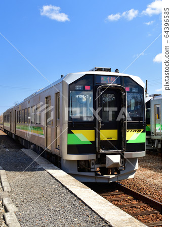 Take a picture of the scenery of an ordinary train departing and arriving at JR Shikaribetsu Station in spring 64396585