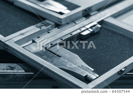 Steel calipers in cases are on a table, blue toned 64397544