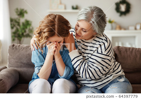Senior mother comforting crying daughter. 64397779