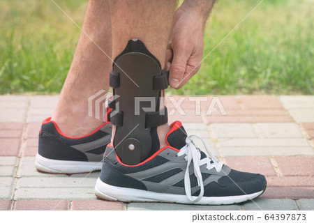 Man wearing ankle brace 64397873