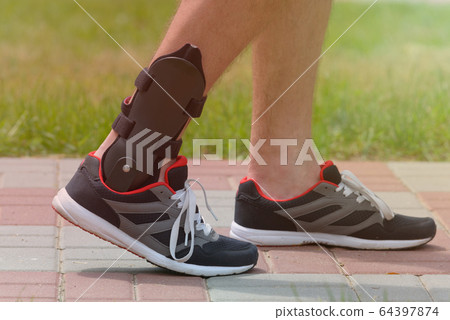 Man wearing ankle brace 64397874