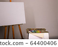 Palette with paints and brushes. Easel and blank 64400406