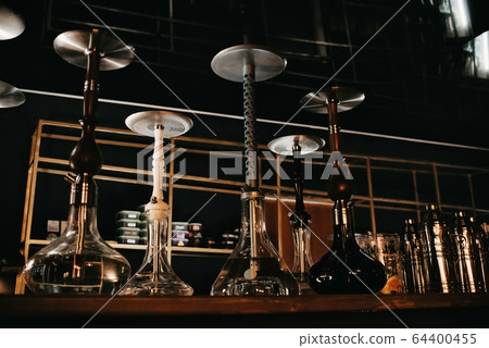 many hookahs with shisha glass flasks and metal bowls 64400455