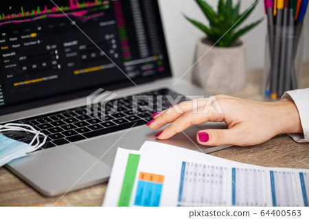 Sad woman is looking at falling stock charts during an epidemic covid-19. 64400563