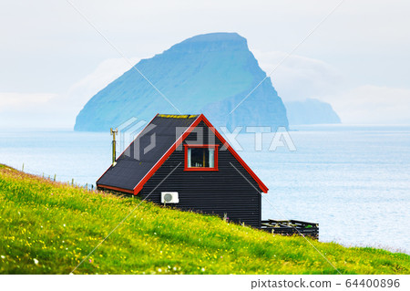 Black house on famous faroese Witches Finger Trail 64400896