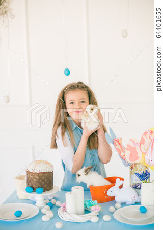 Cute girl with easter bunnies in the room decorative for the holiday. Easter mood 64401655