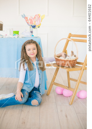 Cute girl with easter bunnies in the room decorative for the holiday. Easter mood Cute girl with easter bunnies in the room decorative for the holiday. Easter mood 64401682