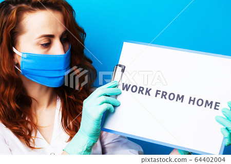 Woman holding blank with inscription work from home calling for stop spreading covid-19. Woman holding blank with inscription work from home calling for stop spreading covid-19. 64402004