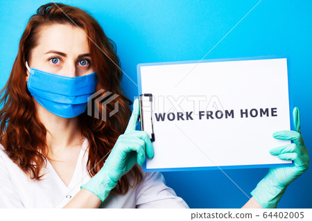 Woman holding blank with inscription work from home calling for stop spreading covid-19. Woman holding blank with inscription work from home calling for stop spreading covid-19. 64402005
