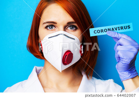Woman in mask and protective gloves holding inscription coronavirus Woman in mask and protective gloves holding inscription coronavirus 64402007