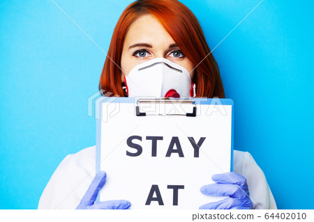 Woman holding blank with inscription stay at home calling for stop spreading covid-19. Woman holding blank with inscription stay at home calling for stop spreading covid-19. 64402010