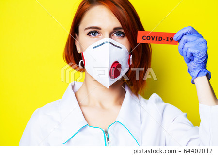 Woman in protective gloves holding inscription covid-19. Woman in protective gloves holding inscription covid-19. 64402012