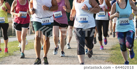 Front view of many runners racing around a lake Front view of many runners racing around a lake 64402018