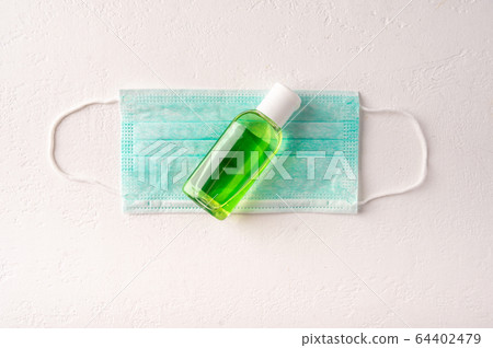 Protective medicine face mask, antiseptic gel on light background. Top view. Copy space Protective medicine face mask, antiseptic gel on light background. Top view. Copy space 64402479