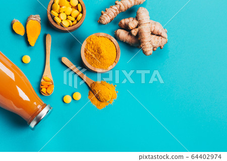 Turmeric in different conditions: fresh, dry root, pills, powder and cut plant. 64402974