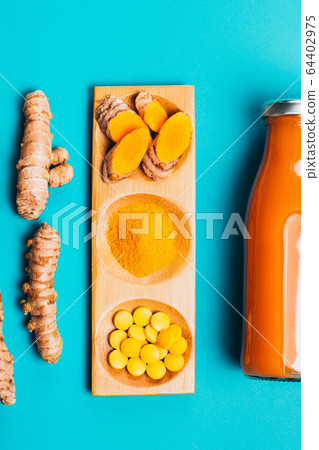 Turmeric in different conditions: fresh, dry root, pills, powder and cut plant. 64402975