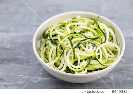 courgette noodles in bowl on gray ceramic 64403834