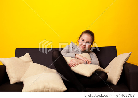 Beautiful little girl lies in a room on the couch Beautiful little girl lies in a room on the couch 64405798