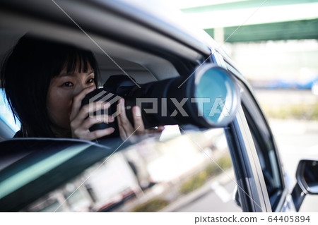 Woman taking pictures from inside the car Woman taking pictures from inside the car 64405894