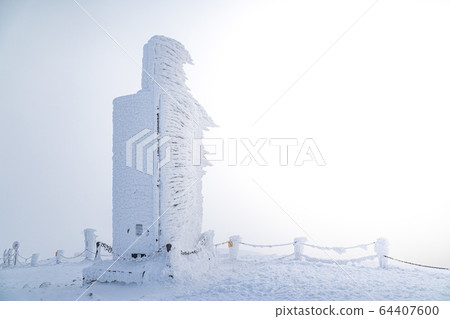 A frosty mound on a summit of Snezka mountain,trigonometric point located on borders with Poland. Winter picture of Czech national park called Krkonose. A frosty mound on a summit of Snezka mountain,trigonometric point located on borders with Poland. Winter picture of Czech national park called Krkonose. 64407600