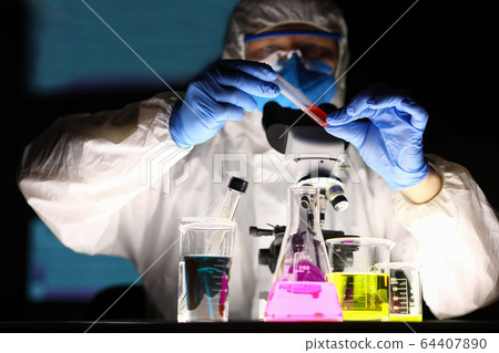 Professional chemist holding test tube 64407890