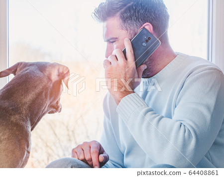 Handsome man and a charming puppy. Close-up Handsome man and a charming puppy. Close-up 64408861