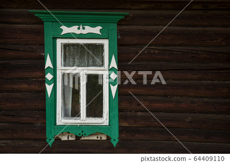 Window with beautiful fretted wooden case . It's a traditional decoration of old russian wooden houses. 64409110