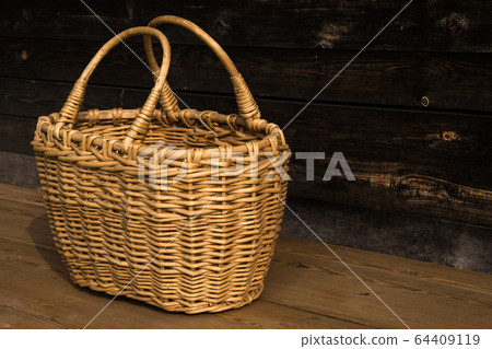 Ancient wicker basket on a wooden background. Selective focus. Free space for text. 64409119