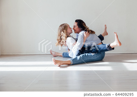 Mom and daughter in denim play in white family love room Mom and daughter in denim play in white family love room 64409295