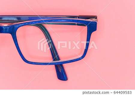 Close up of Blue glasses on pink background, top view. Close up of Blue glasses on pink background, top view. 64409583