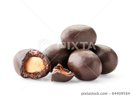 A pile of peanuts in chocolate whole and half on a A pile of peanuts in chocolate whole and half on a 64409584