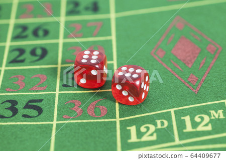 roll of the red dice on a game table in a casino 64409677