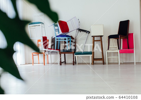 lots of different chairs in the interior of the white room 64410108