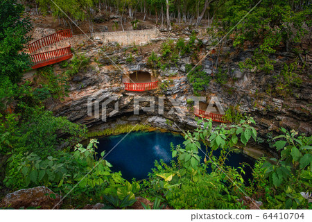 Cenote Ecoturistico X-cajum with blue clear water. Cenote Ecoturistico X-cajum with blue clear water. 64410704