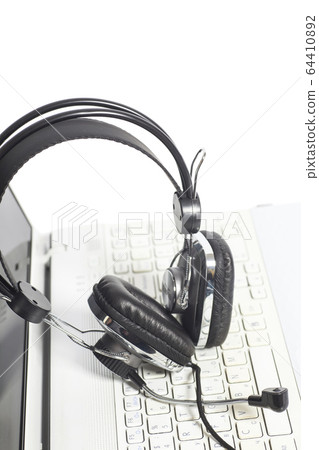 Headset on laptop computer keyboard.Communication Headset on laptop computer keyboard.Communication 64410892