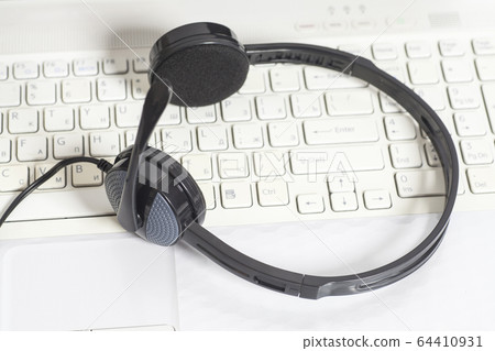 headset on laptop computer keyboard 64410931