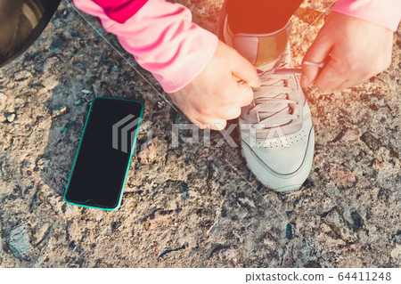 Top view of legs of a female runner preparing to Top view of legs of a female runner preparing to 64411248